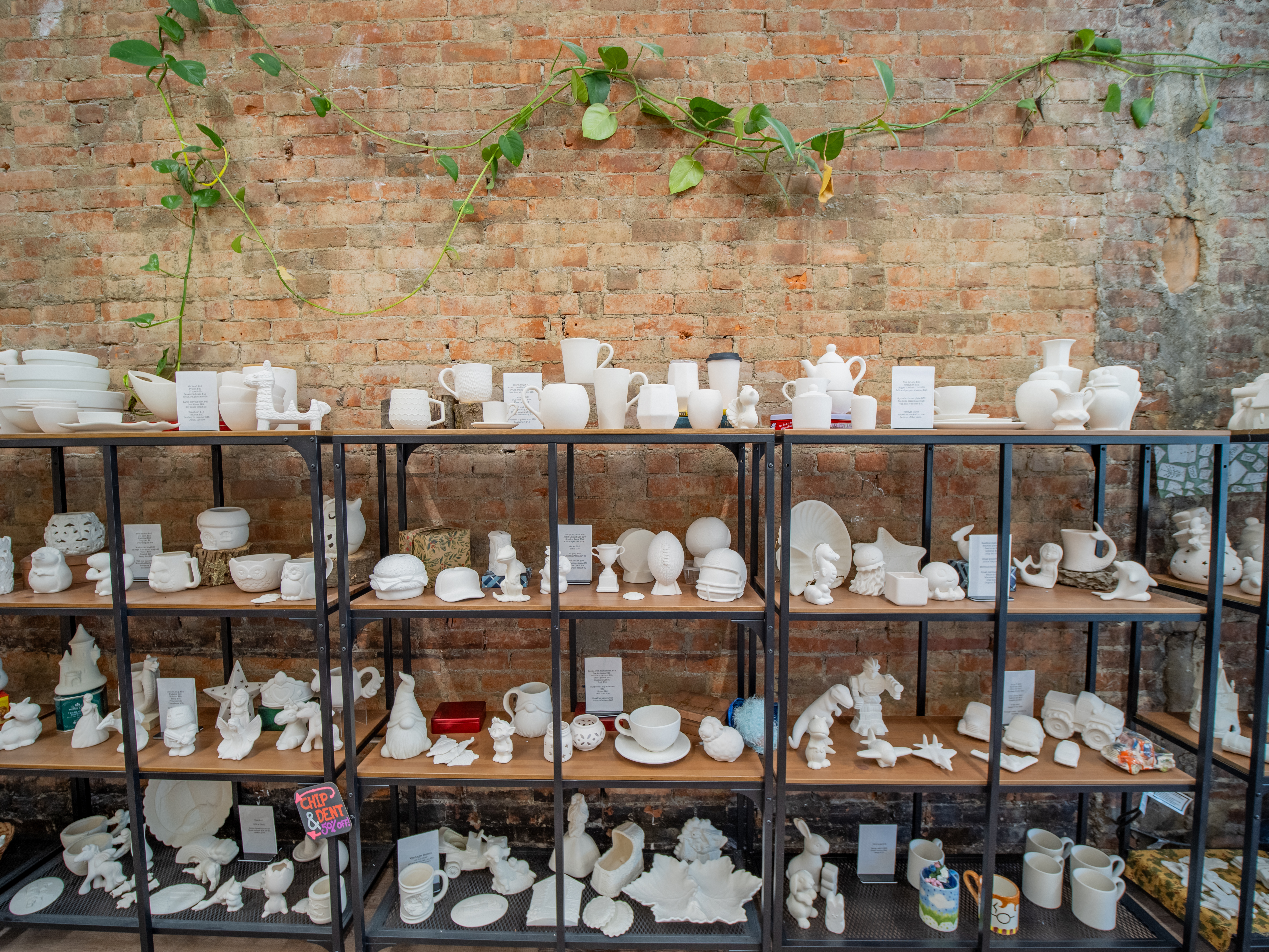 shelves filled with ready-to-paint pottery pieces at Pearl City Clay House, Jamestown, NY