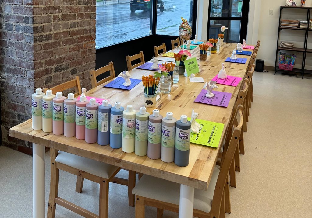 a large table in the Pearl City Clay House studios, set up for a Paint Your Own Pottery birthday party.