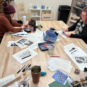 Participants creating blackout poetry art during a meditation and creativity workshop at Pearl City Clay House, Jamestown, NY