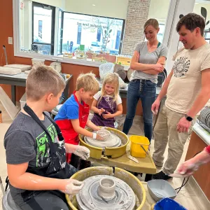 Parents and children learning to use the pottery wheel together at Pearl City Clay House in Jamestown, NY.