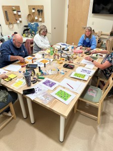 Student using gelatin plate printing techniques to create textured art prints at Pearl City Clay House, Jamestown, NY.