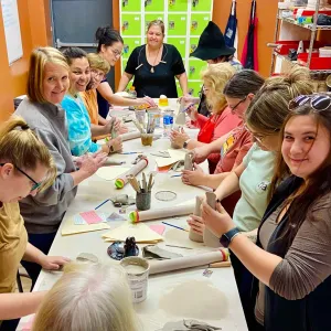 Students gathered around a long table hand-building clay projects at Pearl City Clay House in Jamestown, NY.