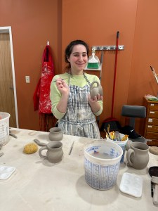 Student shaping a clay mug by hand during a pottery class at Pearl City Clay House in Jamestown, NY.